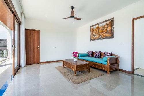 a living room with a blue couch and a table at Akasia Hill Villas in Nusa Dua