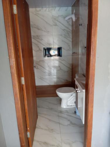 a bathroom with a toilet and a sink at Tô na praia in Matinhos
