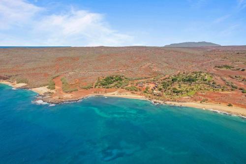 an aerial view of a beach and the ocean at Beautiful Beachfront Townhouse 3bdrm 2bth with outside day bed OR overflow bedroom in Maunaloa