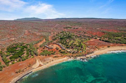 an aerial view of a beach and the ocean at Beautiful Beachfront Townhouse 3bdrm 2bth with outside day bed OR overflow bedroom in Maunaloa