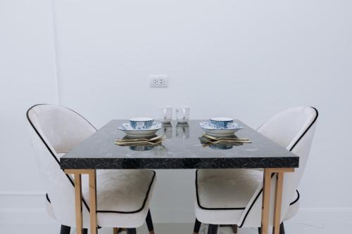 a dining room table with four chairs and a black marble table at The Empire Tower k in Jomtien Beach