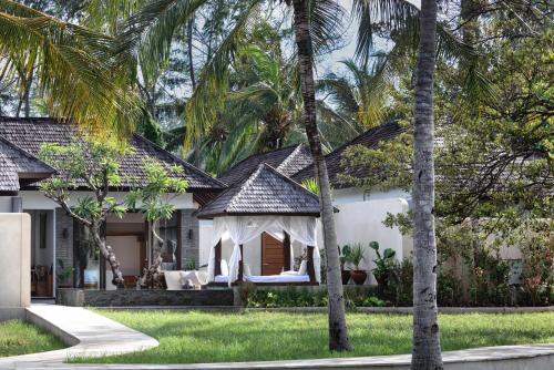 a white house with a gazebo in the yard at Pondok Santi Estate in Gili Trawangan