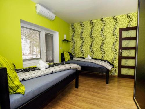 two beds in a room with green walls and a window at Villa in Fren tát near Ski Resorts & Jacuzzi in Frenštát pod Radhoštěm