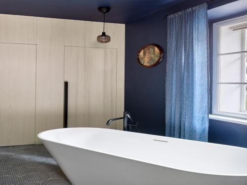 a large white tub in a bathroom with a window at Villa in Javorek near Zlamanec Park in Javorek
