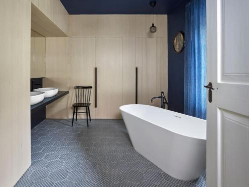 a bathroom with a tub and two sinks and a chair at Villa in Javorek near Zlamanec Park in Javorek
