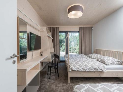 a bedroom with a bed and a desk with a computer at Villa in Bohemia with barbecue in Bedřichov
