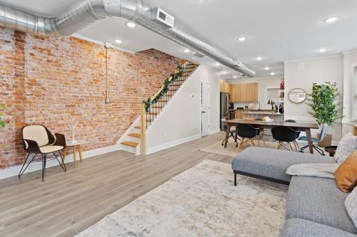 un soggiorno a pianta aperta con parete in mattoni di Loopin Around Atlantic City Luxe 5BR Townhouse in Orange Loop ad Atlantic City