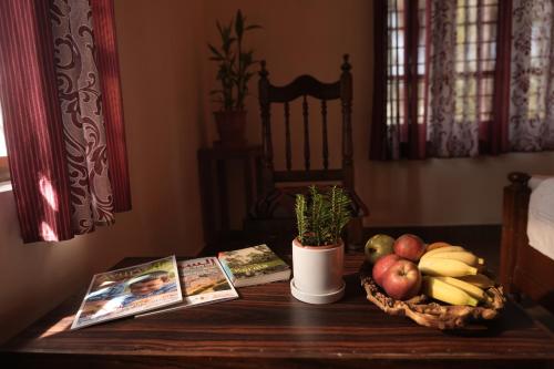 a table with a basket of fruit and magazines on it at Namasthe Ayurveda and Yoga Retreat Cochin in Nedumbassery