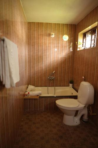 a bathroom with a toilet and a bath tub at Namasthe Ayurveda and Yoga Retreat Cochin in Nedumbassery
