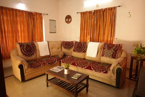 a living room with a couch with pillows on it at Namasthe Ayurveda and Yoga Retreat Cochin in Nedumbassery