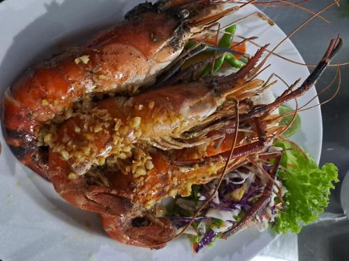 two lobsters on a plate with a salad at The Nature Park Villa in Sigiriya
