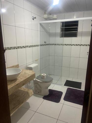 a bathroom with a toilet and a sink at Morada Vitória in Ubatuba