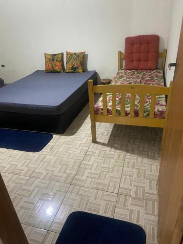 a room with two beds in a room with a floor at Morada Vitória in Ubatuba
