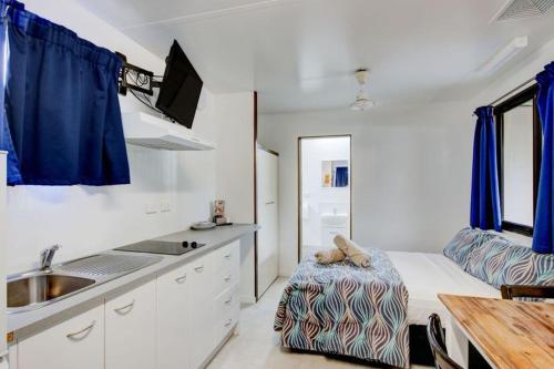 a kitchen with a bed and a sink in a room at Kurrimine Beach Holiday Park in Kurrimine Beach