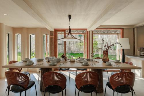 a dining room with a large wooden table and chairs at TANPURI Watket - 8-Bedrooms Villa with Private Pool in the Old Town City - PRIME LOCATION in Chiang Mai