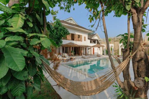 an image of a villa with a hammock by a pool at TANPURI Watket - 8-Bedrooms Villa with Private Pool in the Old Town City - PRIME LOCATION in Chiang Mai