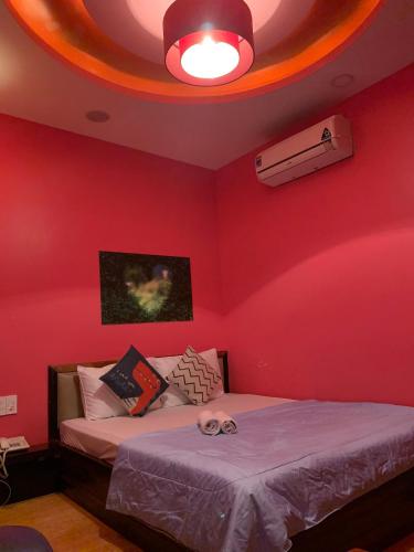 a room with two beds and a red wall at KS Tình Nhân Sach Hotel in Ho Chi Minh City