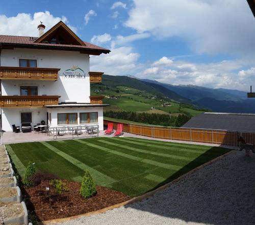 a house with a lawn in front of it at Pension Sonnenhof in Maranza