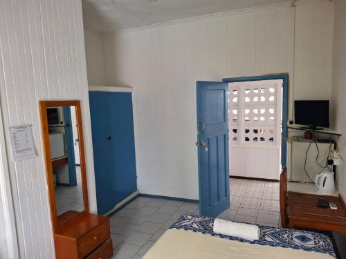a room with a bed and a blue door at Tavua Hotel Ismail Investments in Tavua