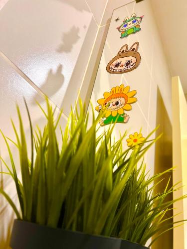 a plant in a room with stickers on the wall at Legoland-8min walk at Kairos Comfort Spacious Suite for Families 1-12pax in Nusajaya