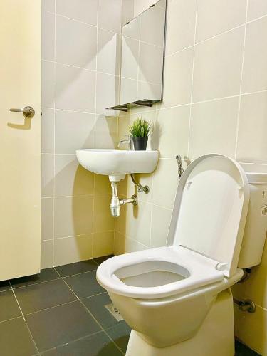a bathroom with a white toilet and a sink at Legoland-8min walk at Kairos Comfort Spacious Suite for Families 1-12pax in Nusajaya