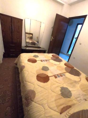 a bedroom with a bed with a blanket on it at Quiet and beautiful apartment near the airport in Tangier
