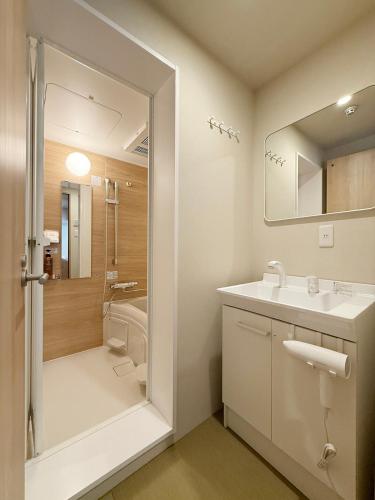 a bathroom with a sink and a shower at Celine Kanayama by b hotel in Hiroshima