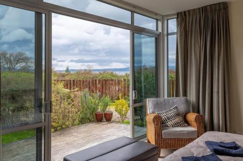 a room with a sliding glass door with a chair and a patio at Lake View Inn in Rotorua