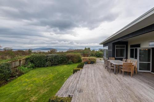 a deck with a table and chairs on a house at Lake View Inn in Rotorua