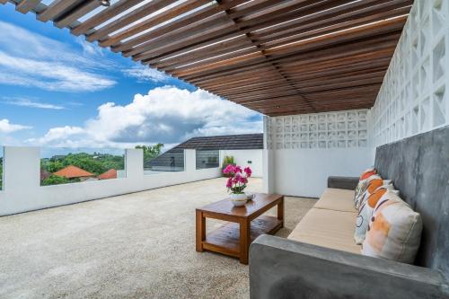 an outdoor living room with a couch and a table at Akasia Hill Villas in Nusa Dua