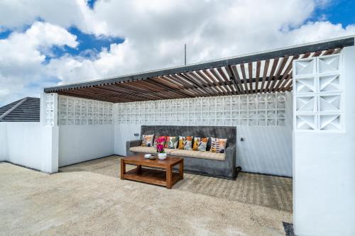 a patio with a couch and a table at Akasia Hill Villas in Nusa Dua