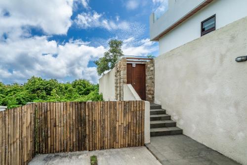 a wooden fence in front of a house with stairs at Akasia Hill Villas in Nusa Dua