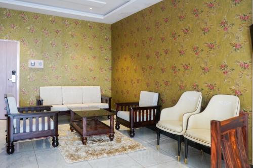 a waiting room with chairs and a table at Hotel Yathin in Mysore