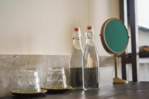 two glass bottles and a mirror on a table at The Interlude Art Retreat in Hoi An