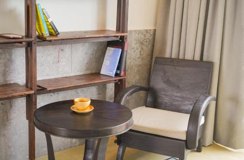 a table and a chair with a coffee cup on it at The Interlude Art Retreat in Hoi An