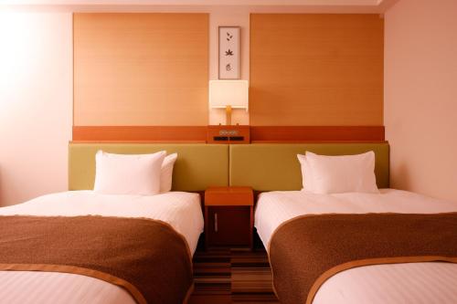 two beds in a hotel room with two beds at Hotel the Lutheran in Osaka