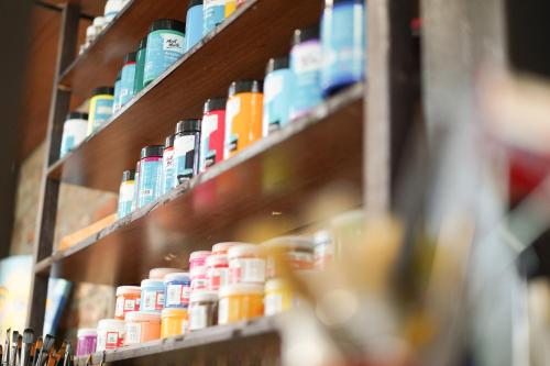 a row of shelves filled with lots of different colored items at The Interlude Art Retreat in Hoi An