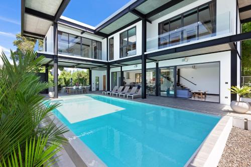 an exterior view of a house with a swimming pool at Loft Style 4BR Villa Sunset Garden 4 with 12m Salt Water Pool, near NaiHarn in Rawai Beach