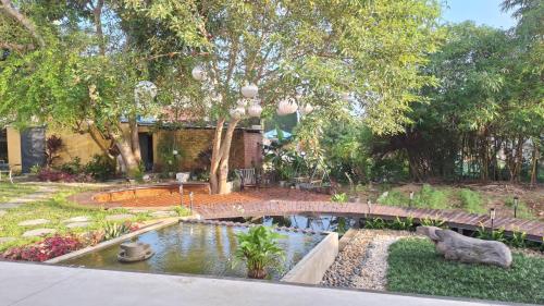 a garden with a pond and a bridge at The Interlude Art Retreat in Hoi An