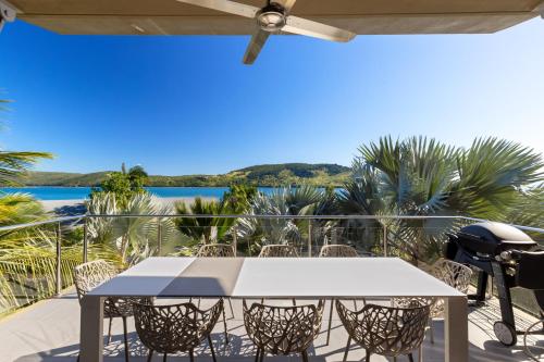 a table on a balcony with a view of the ocean at Yacht Club Villas on Hamilton Island by HIHA in Hamilton Island