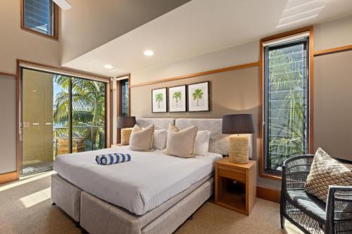 a bedroom with a large bed and a chair at Yacht Club Villas on Hamilton Island by HIHA in Hamilton Island