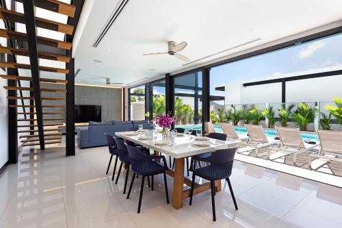 an open dining room with a table and chairs at Loft Style 4BR Villa Sunset Garden 4 with 12m Salt Water Pool, near NaiHarn in Rawai Beach