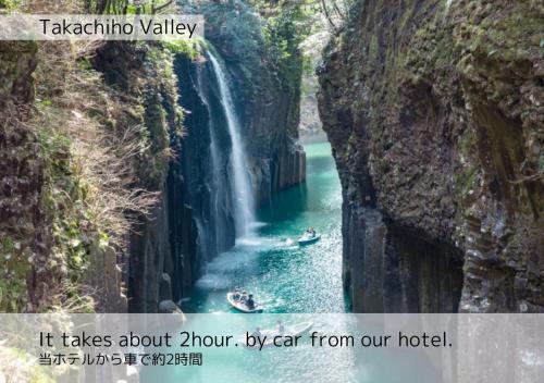 a waterfall in a canyon with boats in the water at K's Street Hotel Miyazaki in Miyazaki