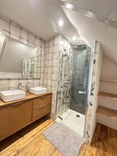 une salle de bain avec deux lavabos et une douche dans l'établissement Au doux repos, à Saint-Quay-Portrieux