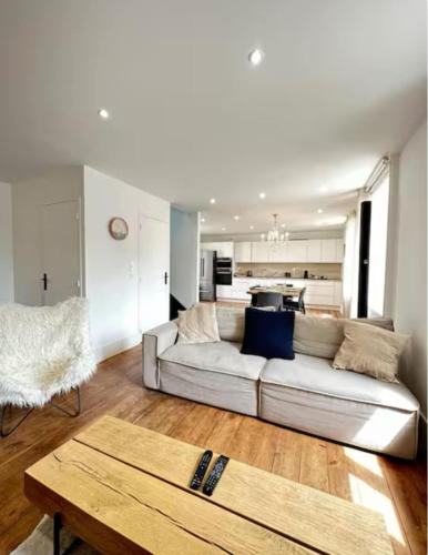 un salon avec un canapé blanc et une table dans l'établissement Au doux repos, à Saint-Quay-Portrieux