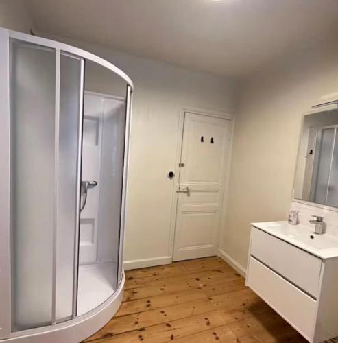 une salle de bain blanche avec une douche et un lavabo dans l'établissement Le spot parfait, à Saint-Quay-Portrieux