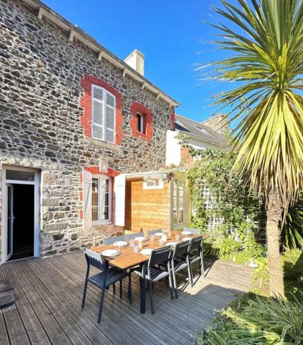 d'une terrasse avec une table et des chaises en bois. dans l'établissement Le spot parfait, à Saint-Quay-Portrieux