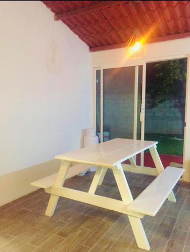 a picnic table with a bench in a room at Casa Oueilhe Vacacional , cerca del mar in Tecolutla