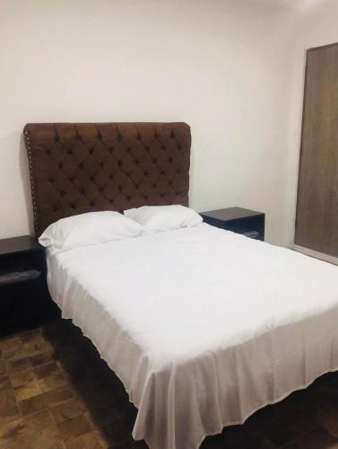 a bedroom with a large bed with white sheets at Casa Oueilhe Vacacional , cerca del mar in Tecolutla