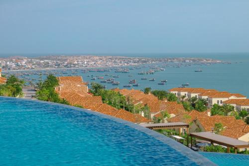 a large swimming pool with a view of the water at Centara Mirage Resort Mui Ne in Mui Ne